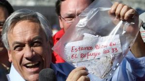 Chile's President Sebastian Pinera holds up a plastic bag containing a message, from miners trapped in a collapsed mine